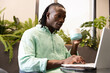 © Wavebreak Media - Using laptop and drinking coffee, man working in modern office environment