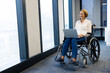 © Wavebreak Media - Smiling woman in wheelchair using laptop, working in modern office environment, copy space