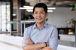 © Wavebreak Media - Smiling businessman with arms crossed standing confidently in modern office