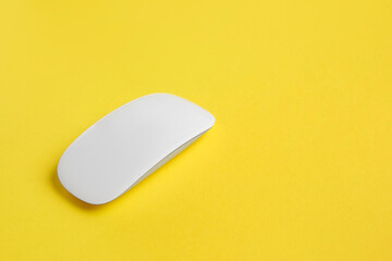 One wireless mouse on yellow background. Space for text