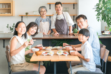 Canvas Print - 家のダイニングで家族団欒して食事する子供と夫婦・親子・三世代家族（二世帯住宅）
