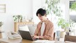 © mapo - 自宅でノートパソコンを使う男性