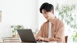 © mapo - 自宅でノートパソコンを使う男性