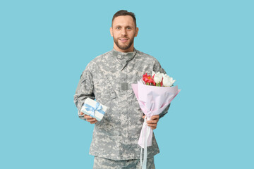 Canvas Print - Young male soldier with flowers and gift box on blue background. International Women's Day