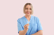 © Pixel-Shot - Female dentist with dental floss picks on pink background