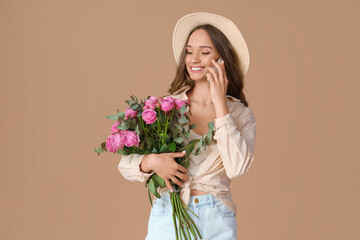 Poster - Beautiful young woman with roses talking by mobile phone on brown background