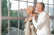 © Pixel-Shot - Mature woman after chemotherapy with her husband looking in window at home
