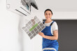 © Pixel-Shot - Female technician changing dirty air conditioner filter at home