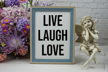 Poster - Live Laugh Love text message motivational and inspiration quote with flowers decoration on white brick wall and wooden background