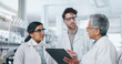 © CoetzeeRising/peopleimages.com - Science, research team and tablet discussion in lab, professional scientists and project for vaccine development. Talking, people and together for innovation medicine, microbiology and collaboration