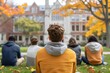 © TEERAPAT - A group of people are sitting on the grass in front of a large brick building