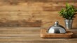 © Paul - Bell metal service set on a rustic wooden table, with a blurred wooden background, capturing a warm, vintage ambiance