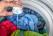 © Ratchapon - Pour laundry detergent with colorful clothes in washing machine