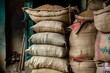 © Iftikhar alam - A row of sand bags neatly stacked next to each other, Bags of rice and beans stacked in a corner