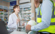 © Wosunan - The pharmacist provides medicine to the engineers who come to buy medicine in the pharmacy.