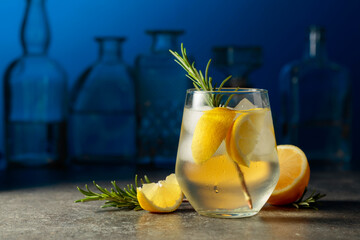 Wall Mural - Cocktail gin tonic with ice, rosemary, and lemon.