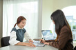 © Prathankarnpap - Businesswomen sharing ideas and discussing business strategy at modern office
