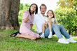 © Stella - Portrait of happy beautiful family in outside garden. Joyful parents and daughter girl relaxing during sitting under tree at green park. Father, mother, and kid child spending time together outdoor.