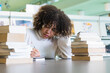 © BUDDHA - Im going to make you so proud. Shot of a young woman studying with a pile of books in a college library and looking thoughtful.