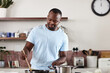 © Hira/peopleimages.com - Cooking, music and stove with man in kitchen of home for diet, health or nutrition recipe. Food, ingredients and vegetables with happy African person stirring pot, earphones and meal preparation