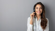 © Mahemud - Portrait of a happy, smiling young support phone operator or confident businesswoman in a headset, against a grey background, with blank copy space for a slogan or text message.