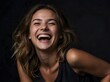© Yael - Portrait of a young woman laughing, black background with copy space