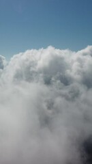 Wall Mural - drone flies over foggy and fluffy clouds. aerial vertical view. blue sky sun and sea fog. abstract a