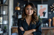 © mediahain.de - professional headshot of a young female entrepreneur with crossed arms, standing in front of a stylish workspace.