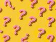 © VICHIZH - Pink question marks clustered on yellow background with central question mark uncertainty and curiosity in business and everyday life