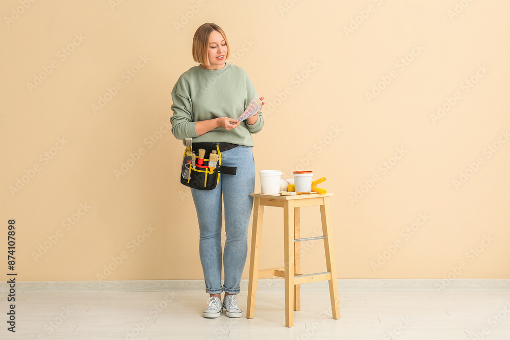 Female decorator with color samples near beige wall
