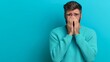 © Nataliia_Trushchenko - A man is crying while wearing a blue sweater. Concept of sadness and vulnerability
