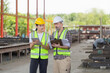 © JU.STOCKER - Engineer and foreman worker team with blueprints checking project at the precast concrete factory site, Engineer and builders in hardhats discussing on construction site