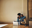 © peopleimages.com - Happy couple, new home and laptop on floor for shopping, research decor ideas and finance plan in living room. Man, woman and technology on internet for bond payment, ecommerce or property investment