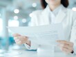 © ontsunan - Business professional reviewing documents in a modern office setting, focusing on paperwork and analysis while holding a printed report.