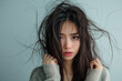 © K2Kstock - Young Asian woman frustrated by damaged hair, messy dry hair