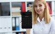 © H_Ko - Portrait of smiling businesswoman accountant holding calculator in hand demonstrates display counting equipment. Finance, economy, banking, office concept