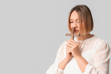 Wall Mural - Adult woman with wooden cross praying on white background