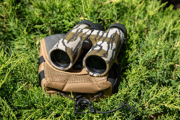 Wall Mural - Modern binoculars. An optical instrument for observation at long distances. Green fir back