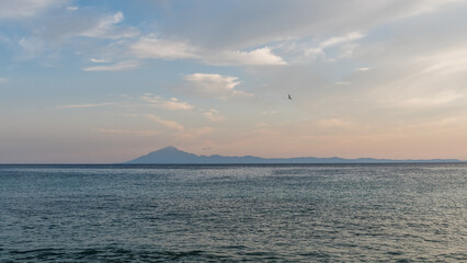 View across the sea from the island of Thassos to distant Mount Athos at sunset