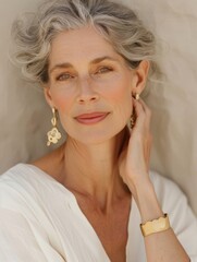 Wall Mural - Elegant woman with wavy gray hair,  soft smile , white summer linen top and gold jewelry, woman with vintage earrings and bracelet