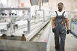 © Serhii - Portrait of African American male engineer in uniform and standing in industrial factory