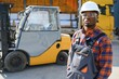 © Serhii - Portrait of a happy African American male worker driving forklift at workplace