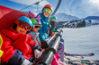 © Sergey Novikov - Smiling family on ski lift, snowy mountains in the background