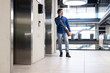 © WavebreakMediaMicro - Talking on smartphone, man standing near elevator in modern office building