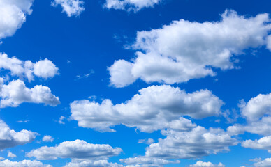 Nice small clouds. Cute fluffy cirrus clouds on a blue sky, background with a gradient effect. Postcard cloudscape