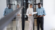 © Wavebreak Media - Business colleagues walking in office, reviewing documents and using smartphone