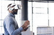 © Wavebreak Media - Using VR headset, man interacting with virtual environment while holding tablet
