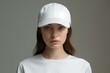 © juliars - Close-up of a young female model sporting a plain white cap and t-shirt on a grey background