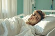 © juliars - Young male patient rests in a hospital bed, bathed in morning sunlight, looking contemplative