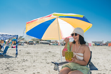 Wall Mural - Pretty latina girl eating ice cream on the beach